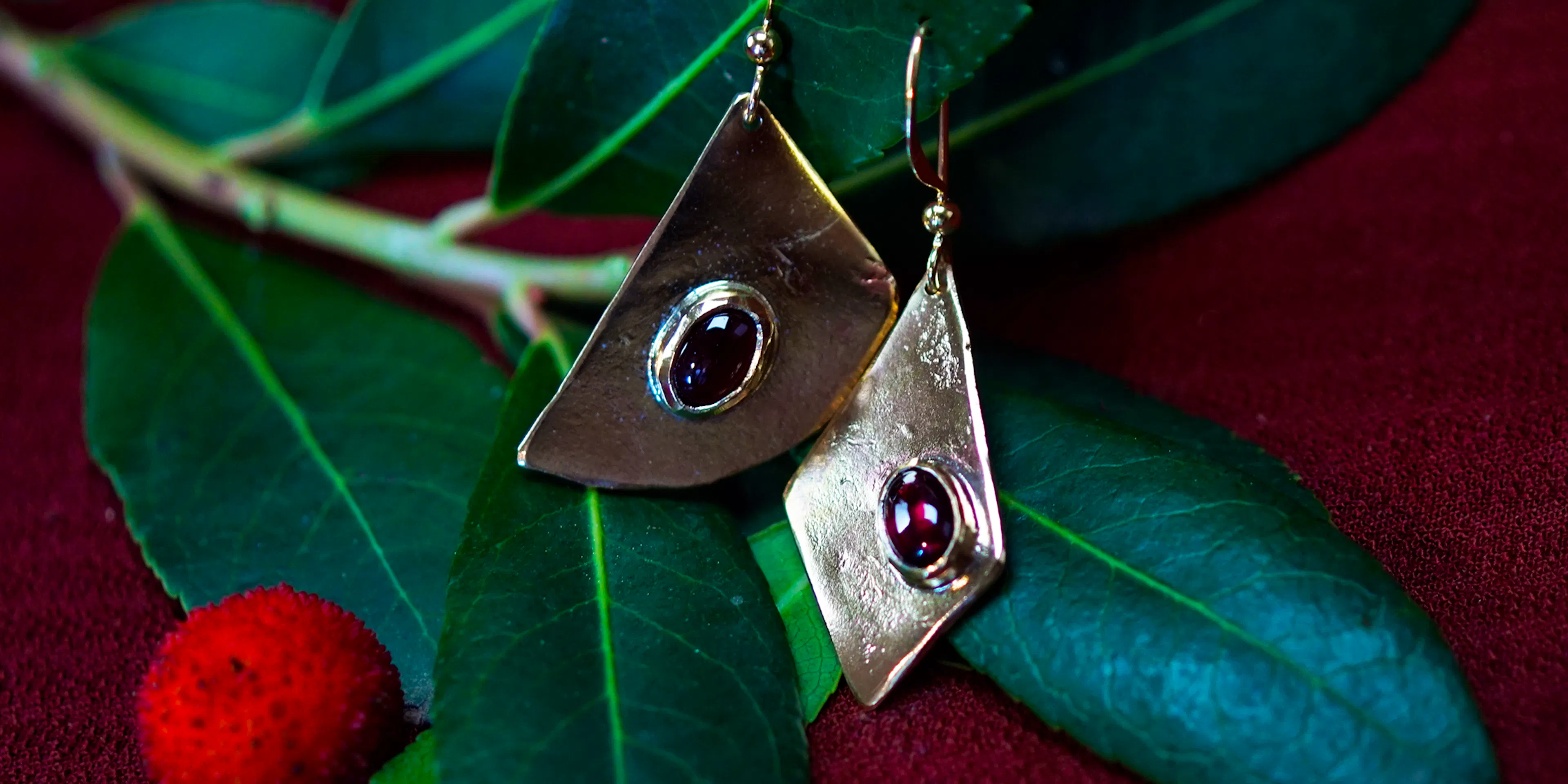 boucles d'oreilles posées sur une branche d'arbousié