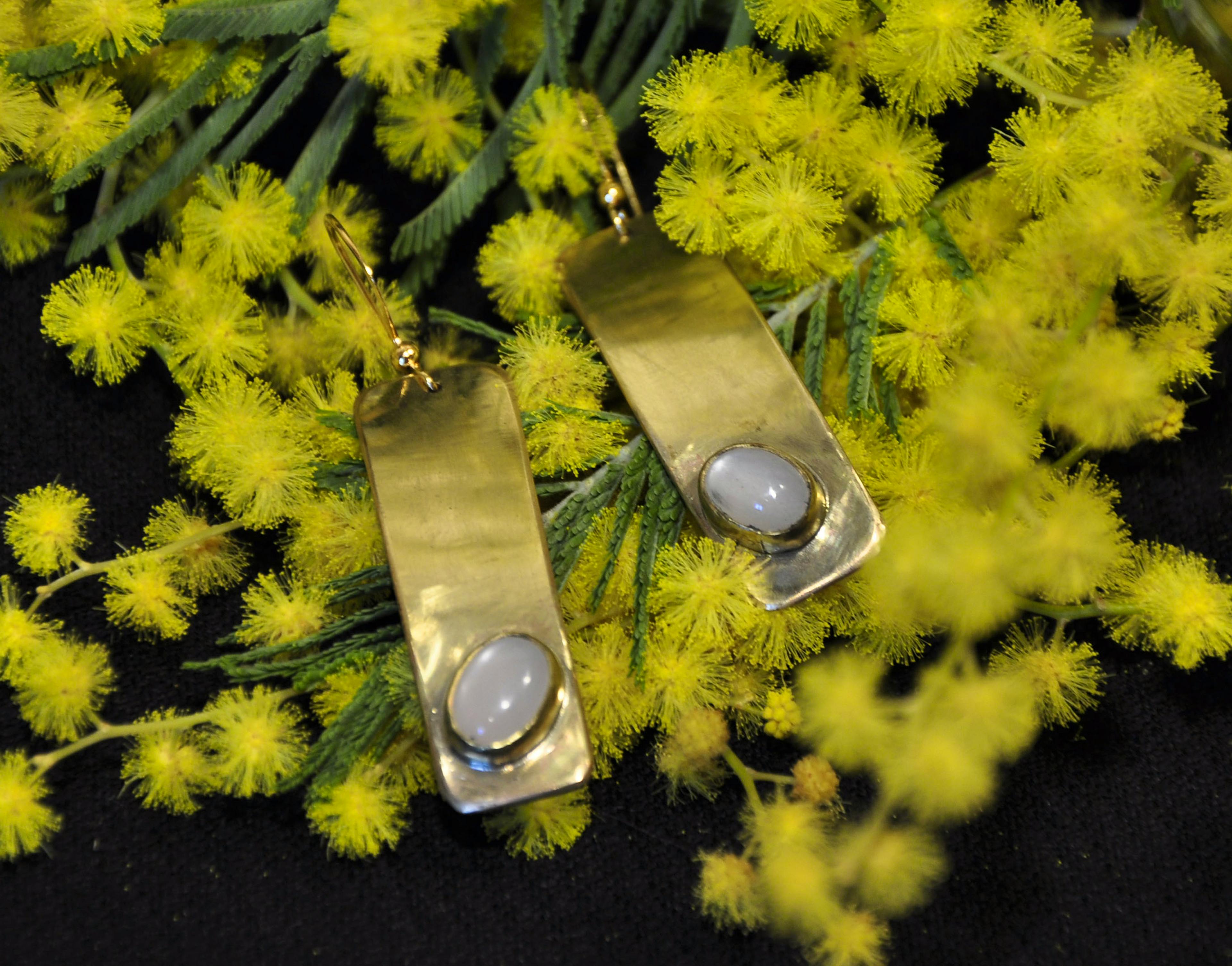 boucle d'oreilles posées sur du mimosa