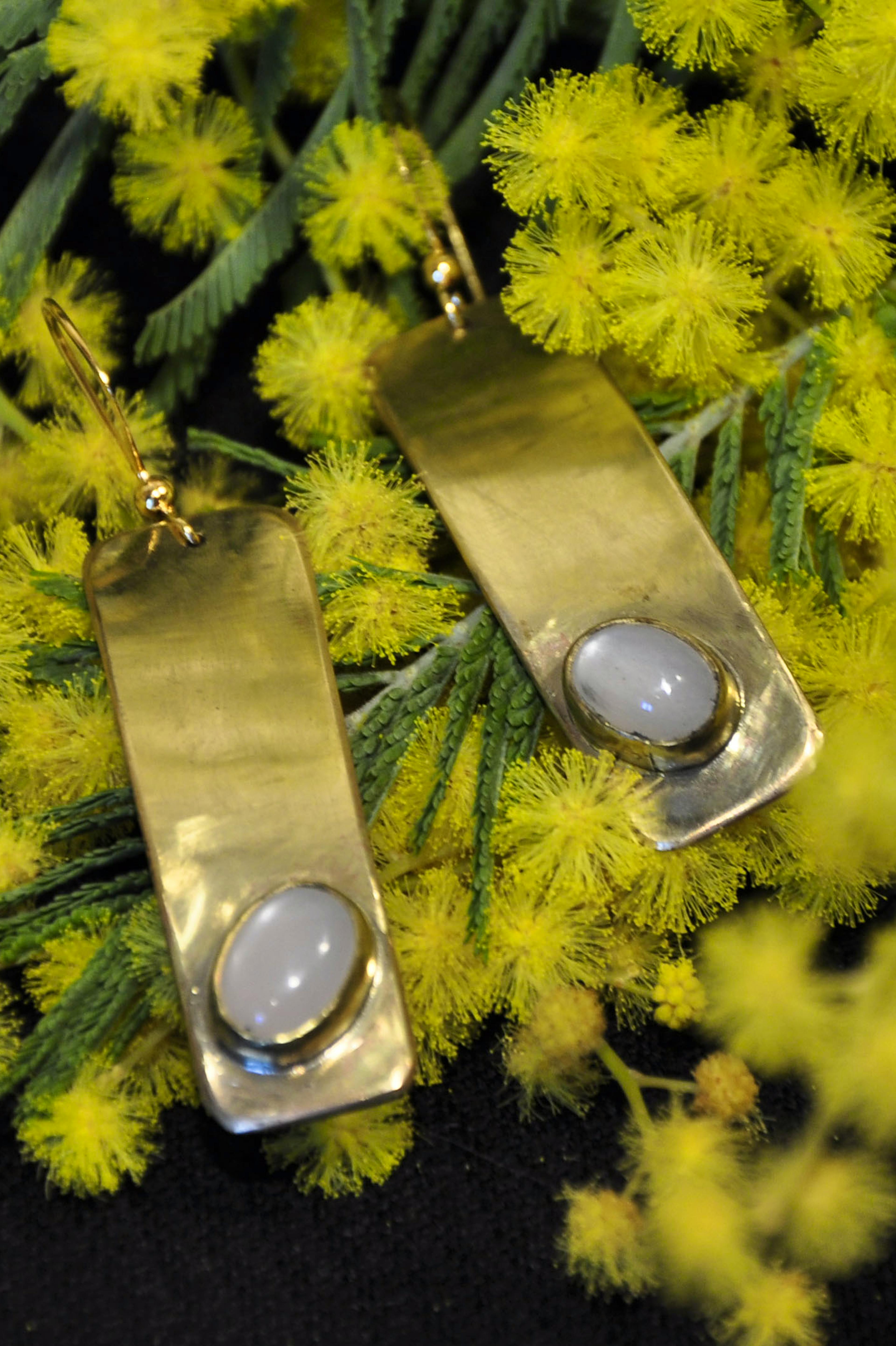 boucle d'oreilles posées sur du mimosa
