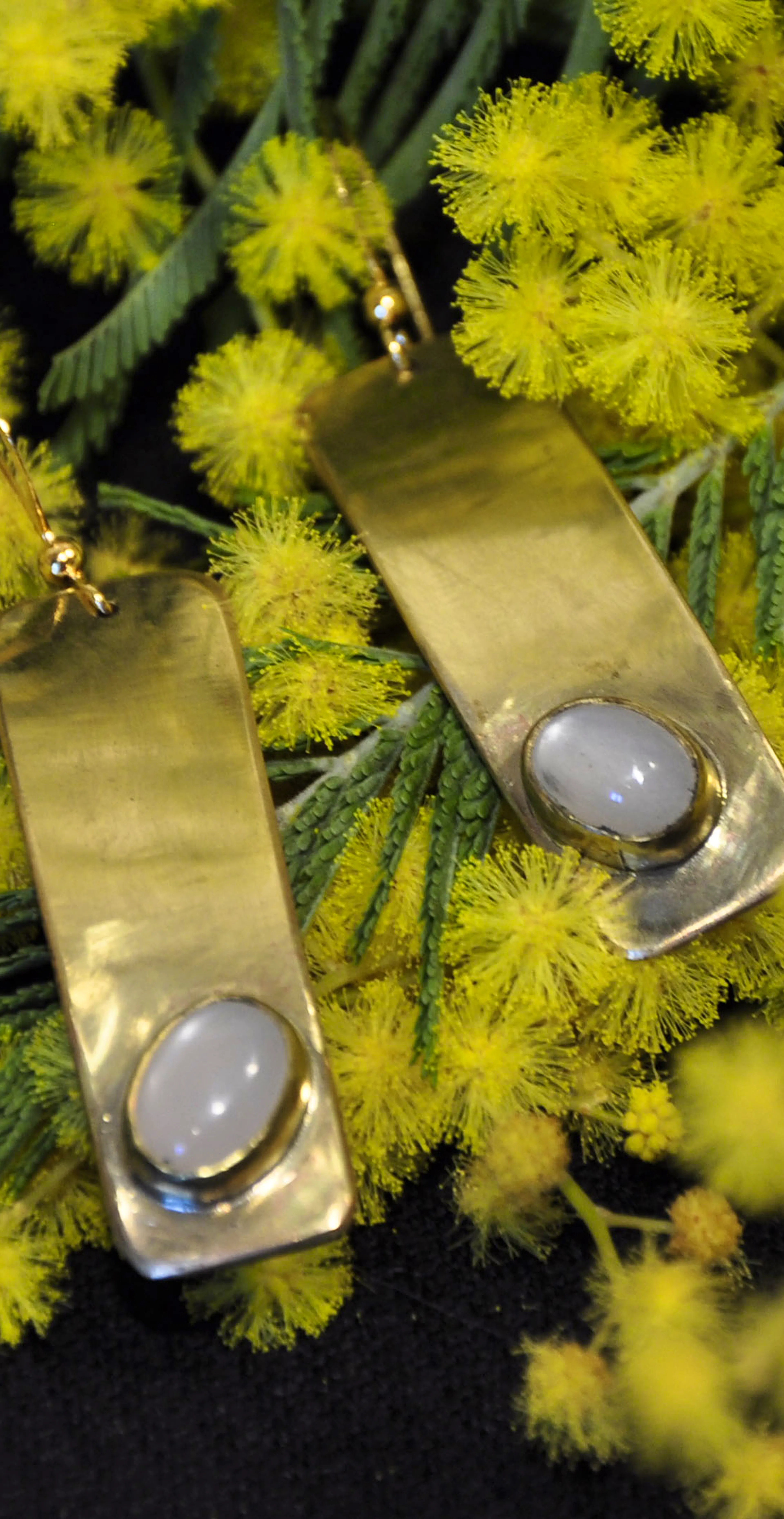 boucle d'oreilles posées sur du mimosa