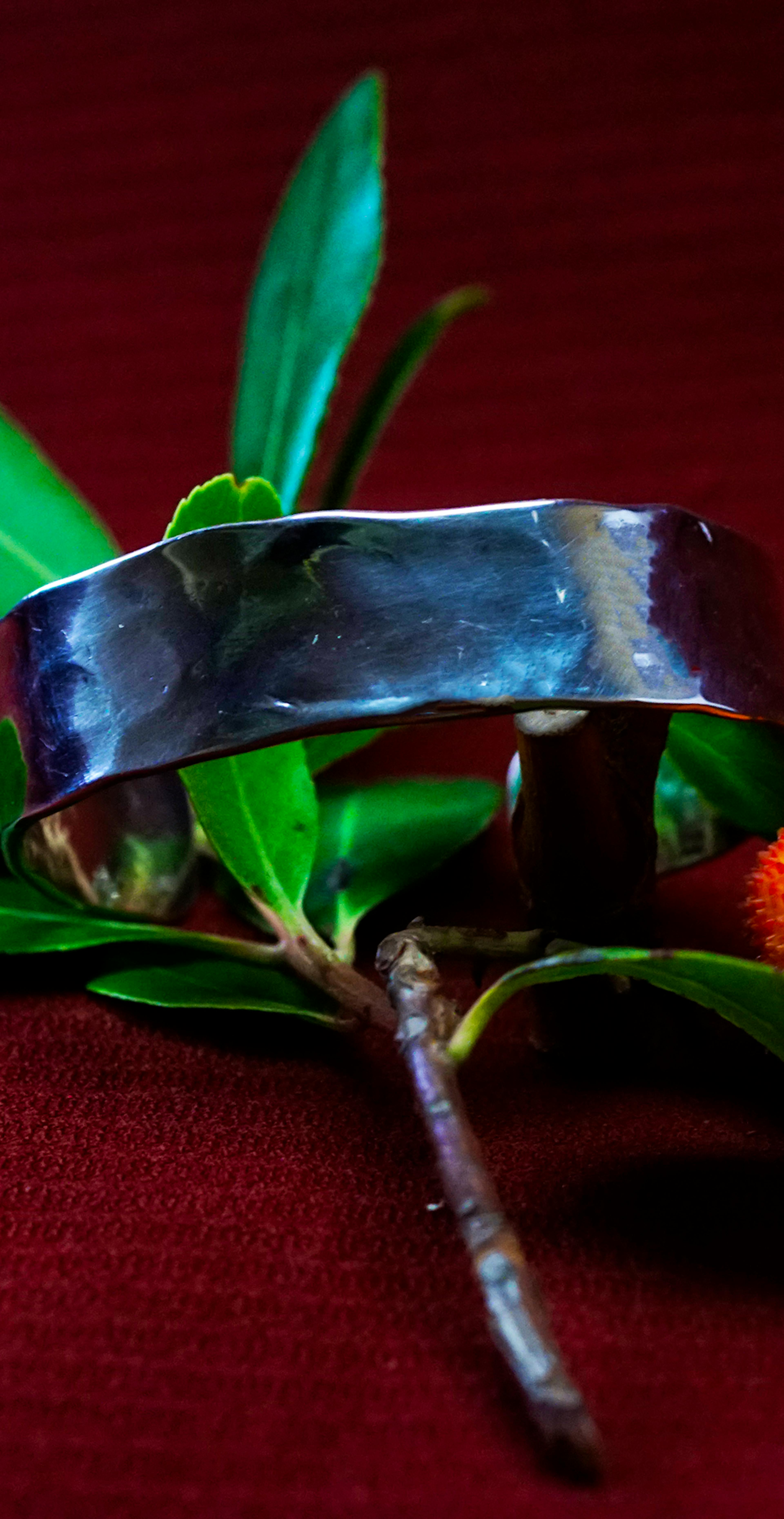 Bracelet cuivre et argent posé sur une branche d'arbousié