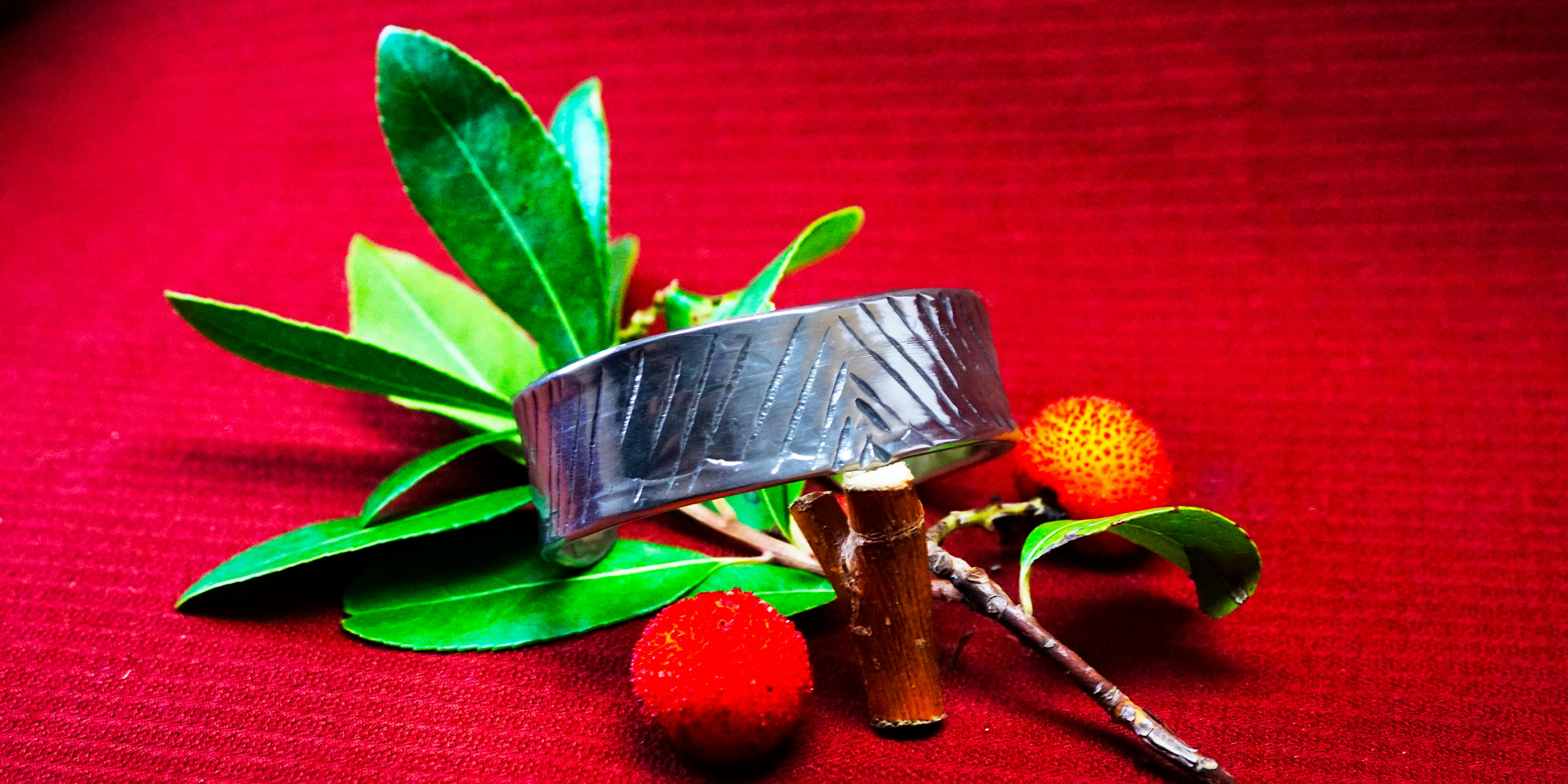 Bracelet cuivre et argent posé sur une branche d'arbousié