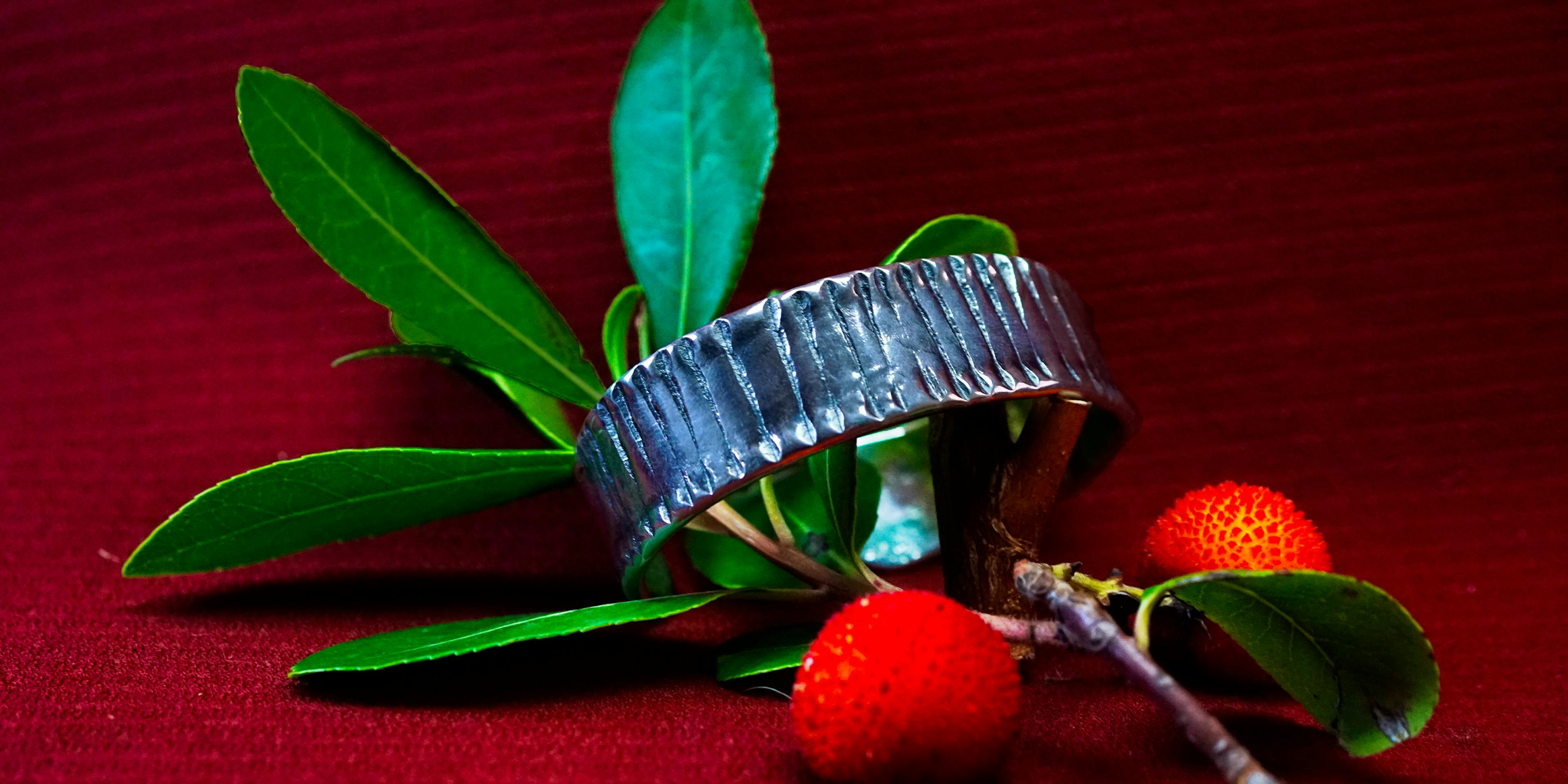 bracelet cuivre et argent posé sur une branche d'arbousié