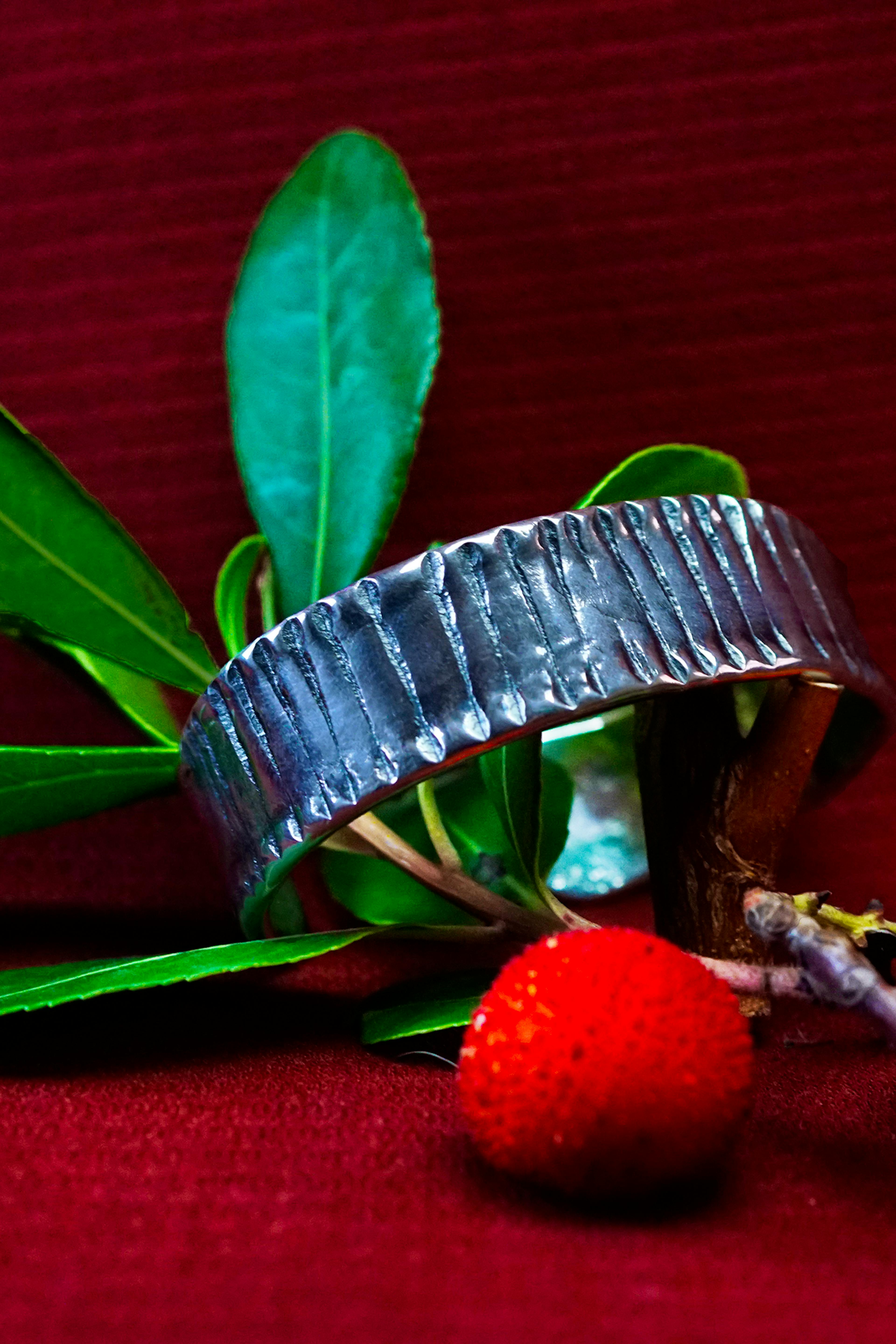bracelet cuivre et argent posé sur une branche d'arbousié