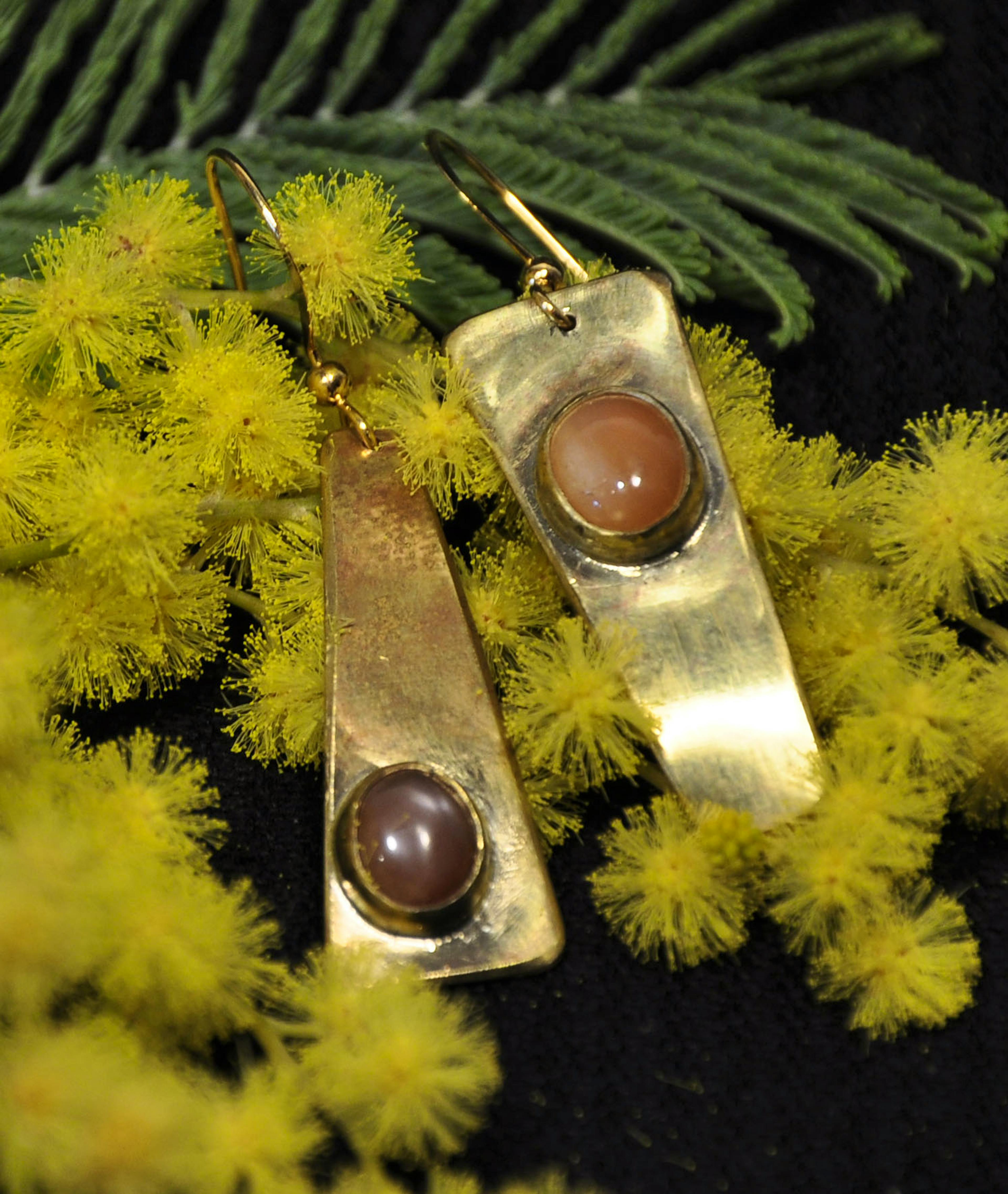 Boucles d'oreilles posées sur du mimosa