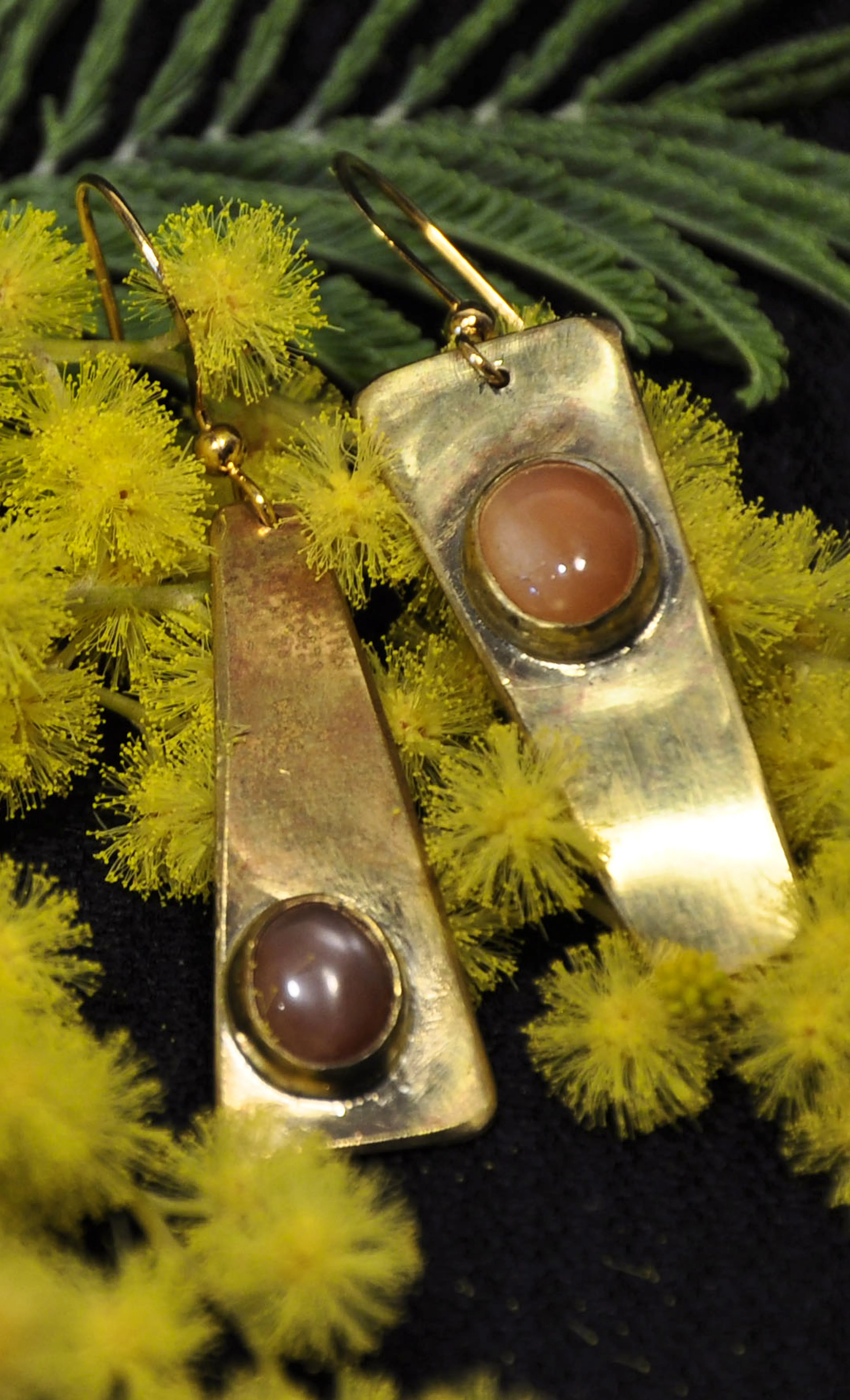 Boucles d'oreilles posées sur du mimosa