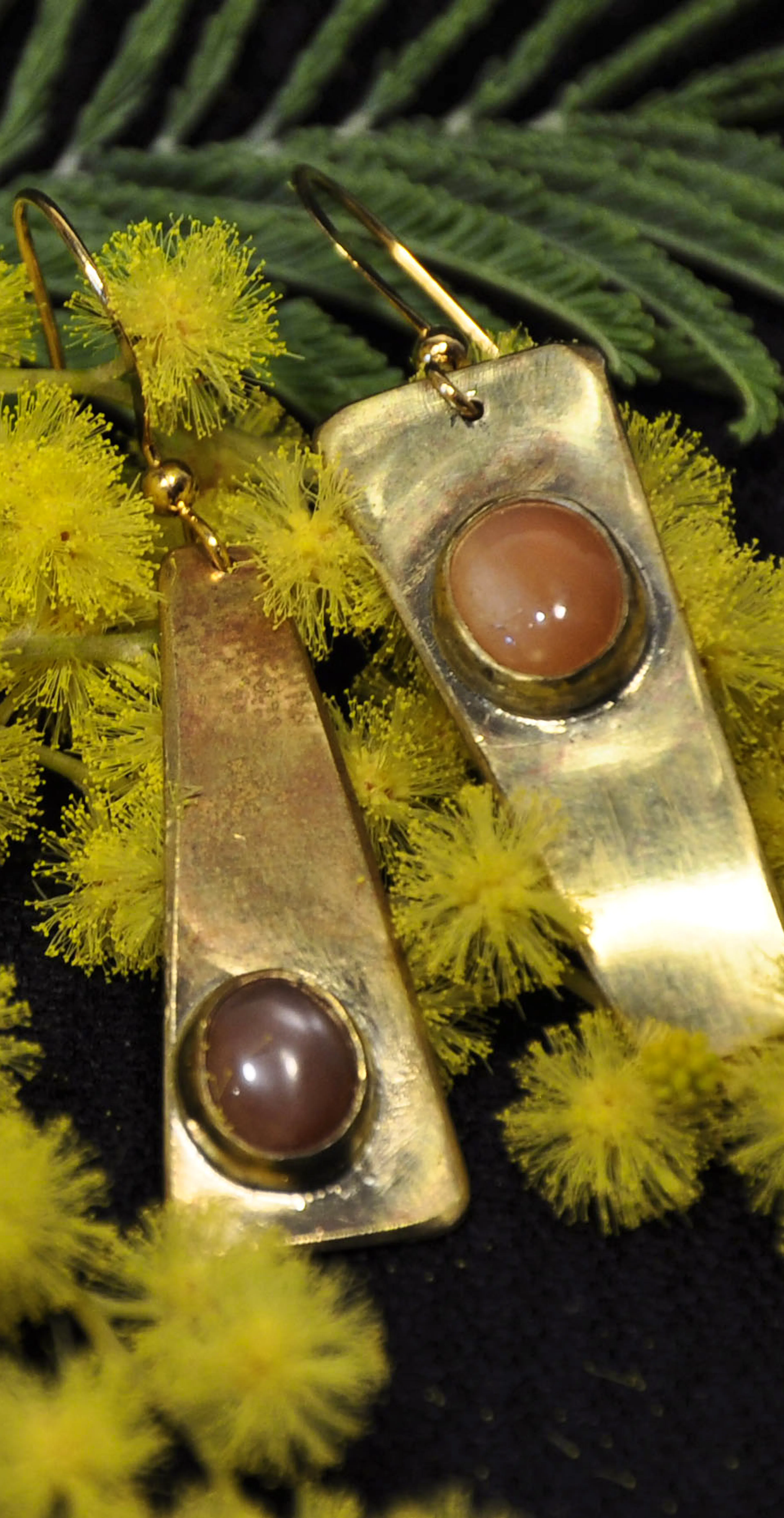 Boucles d'oreilles posées sur du mimosa