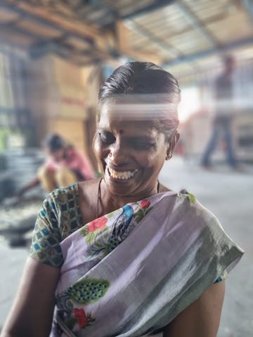 Smiling women working on packing candles at a small candle factory