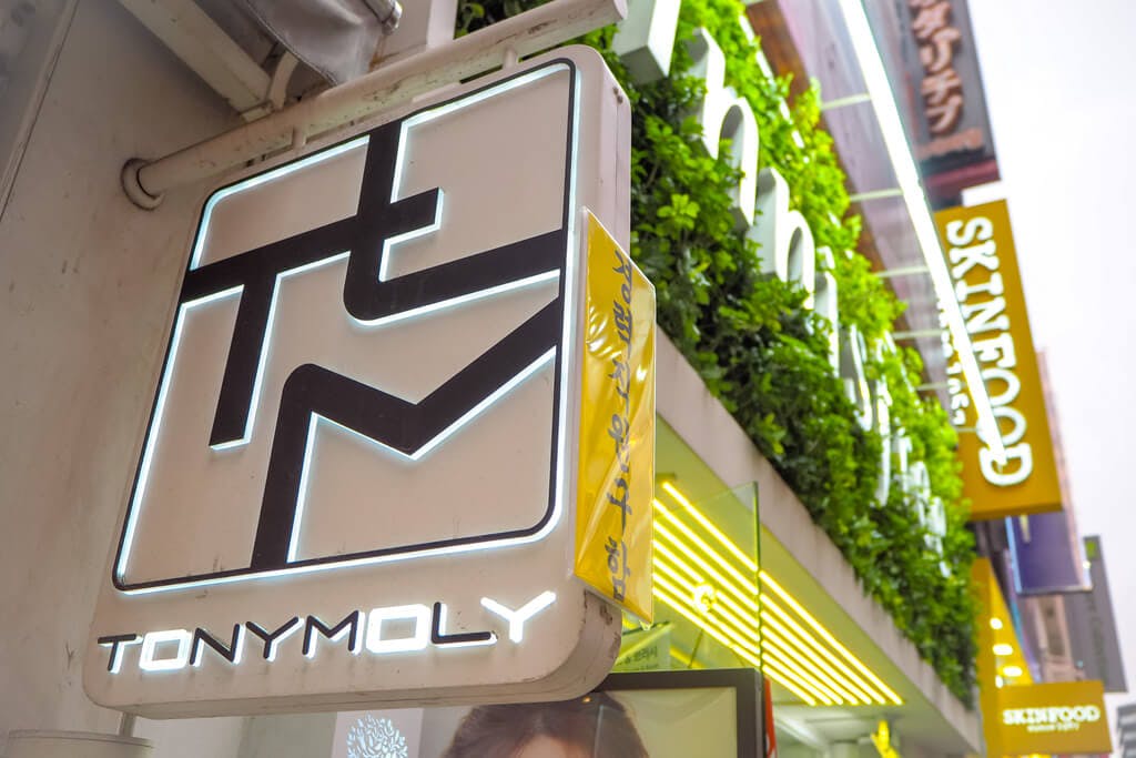 A TonyMoly sign in Japan with an Innisfree and Skinfood sign in the background.