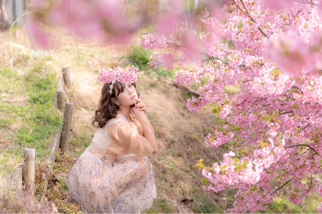 A Japanese woman takes in the beauty of cherry blossoms in a park
