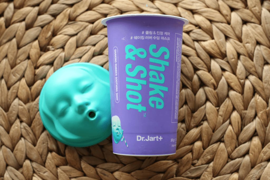 One of the Dr.Jart+ masks from the Shake & Shot series with a purple package and a blue baby face-shaped lid.