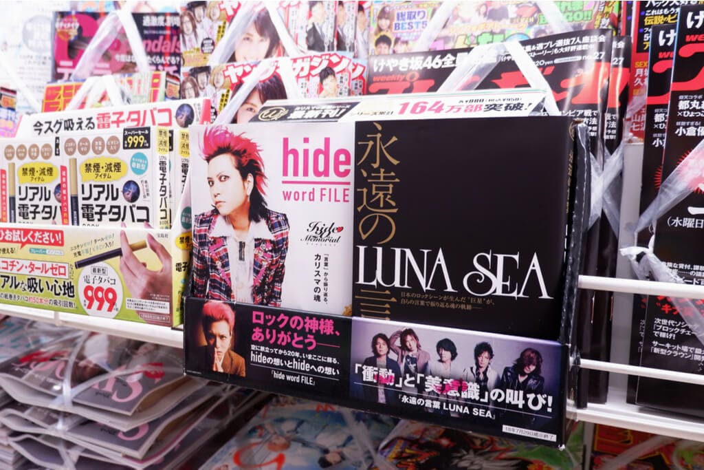 A photo of Hide in visual Kei clothing next to a book of Luna Sea.