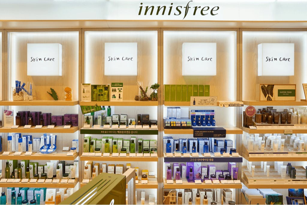 The interior of an Innisfree, a K-beauty store that sells Korean lip glosses, makeup, and skincare, with their famous skin care wall.