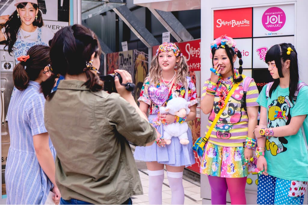 Three girls in Decora fashion being interviewed by two people in front of a Harajuku building