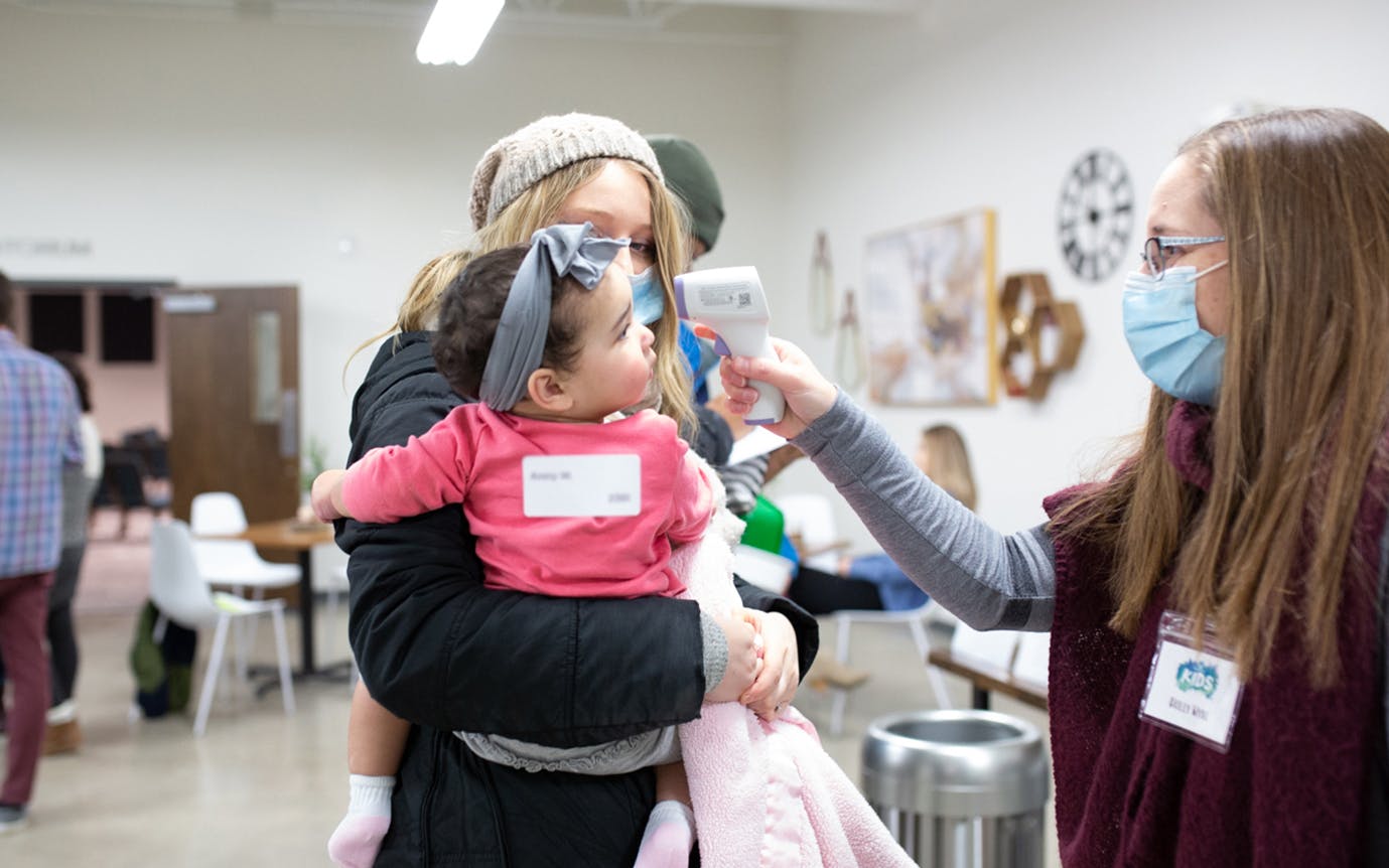A mother checking her child into the North Pines Kid's Program.