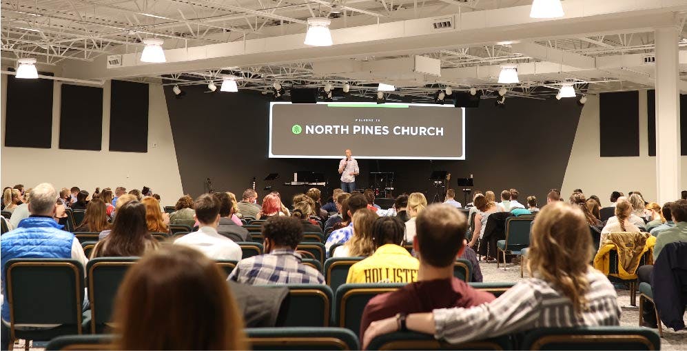 Auditorium full of Sunday service attendees listening to teaching.