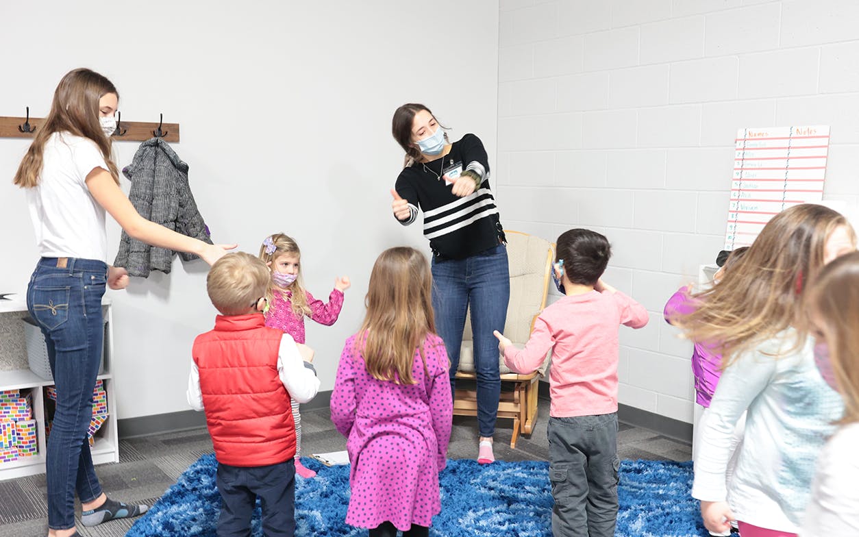 Teachers and children worshiping together with fun movements.