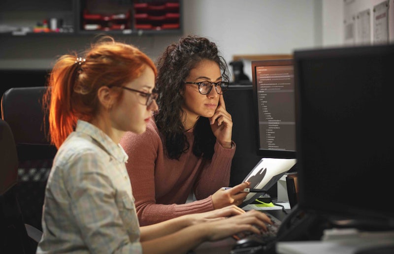 Pair programmers looking at code