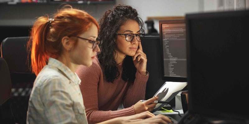 Pair programmers looking at code