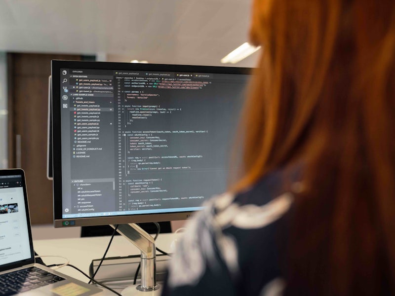 Female software engineer working on code on computer