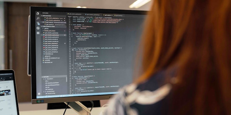 Female software engineer working on code on computer