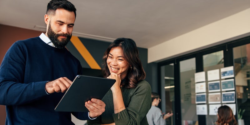 A man and a woman looking at a tablet