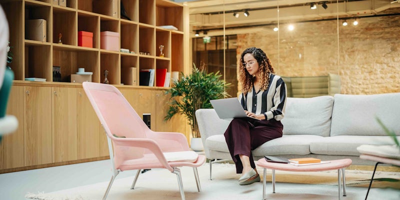 Woman looking at laptop in office space