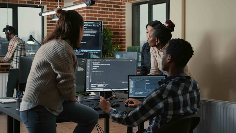 A group of programmers looking at code in the office