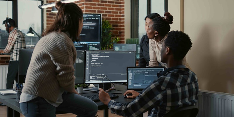 A group of programmers looking at code in the office
