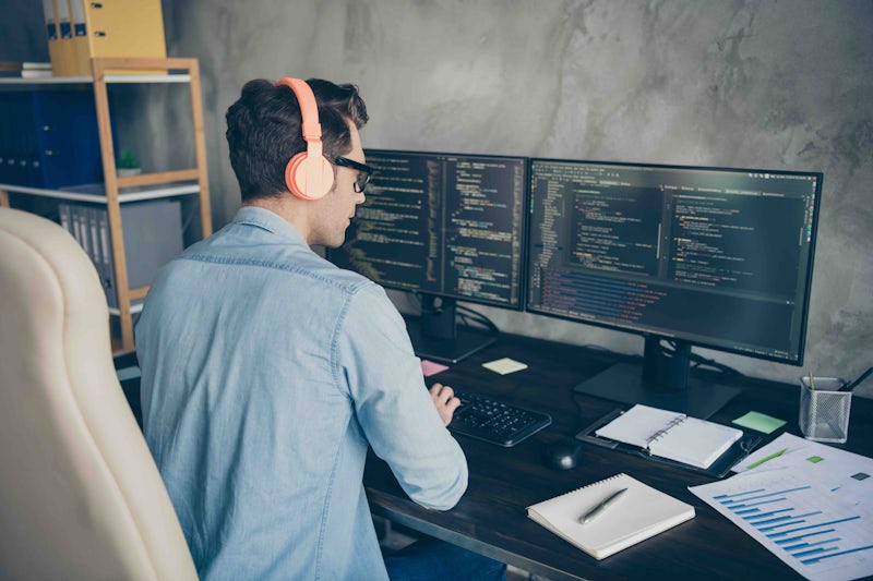 Male programming at home on desktop