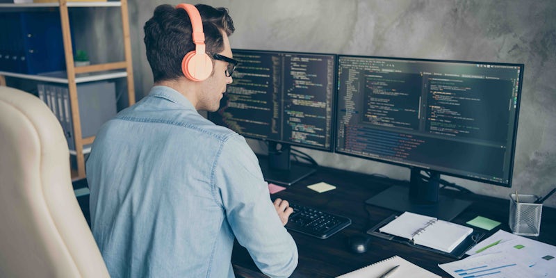 Male programming at home on desktop