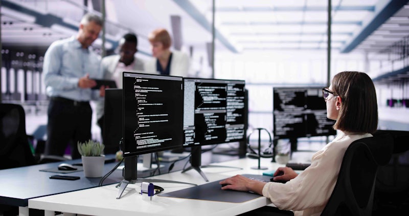 Female programmer looking at code