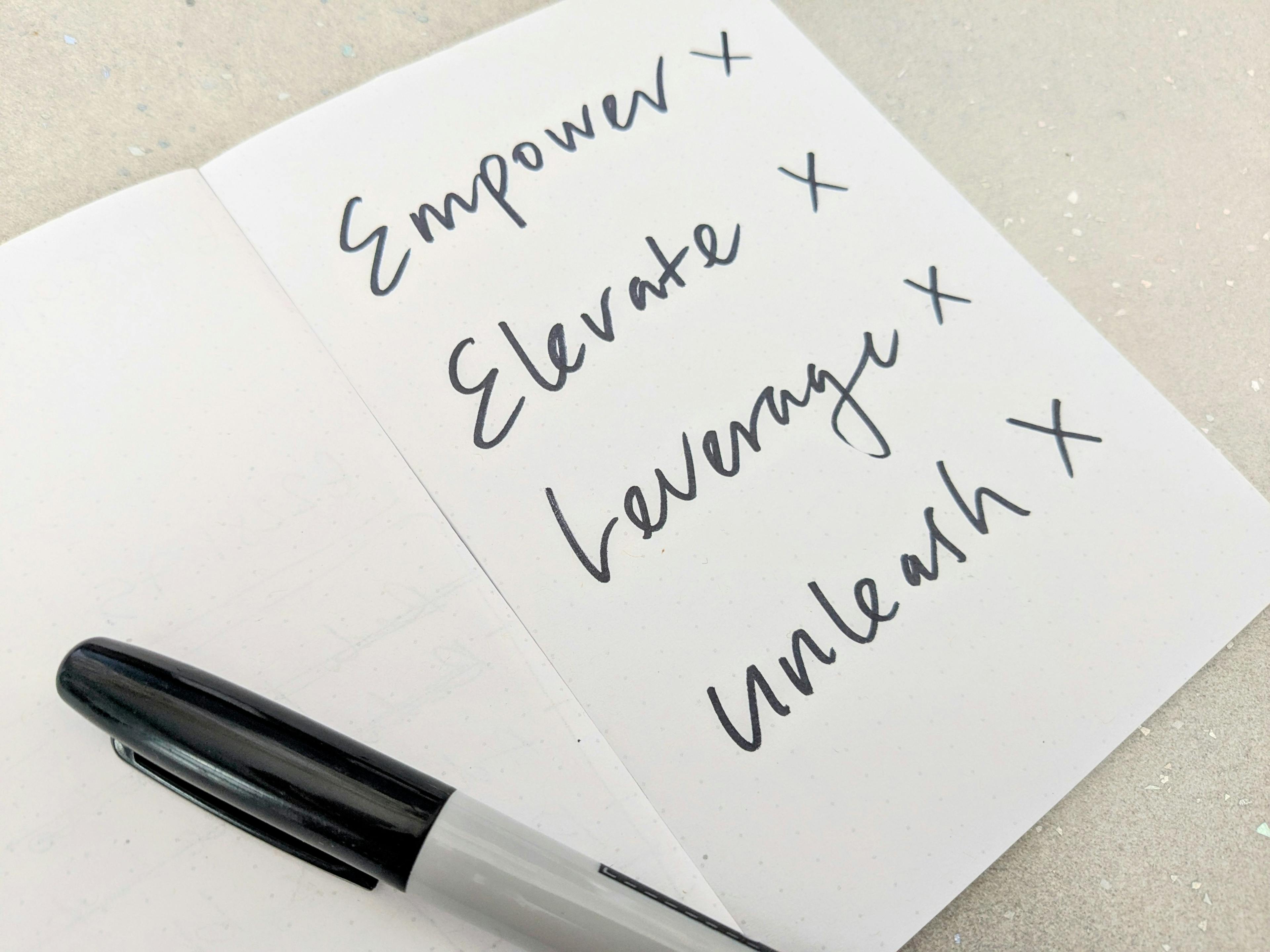 A notebook with the words, 'Empower, Elevate, Leverage and Unleash' written in black marker