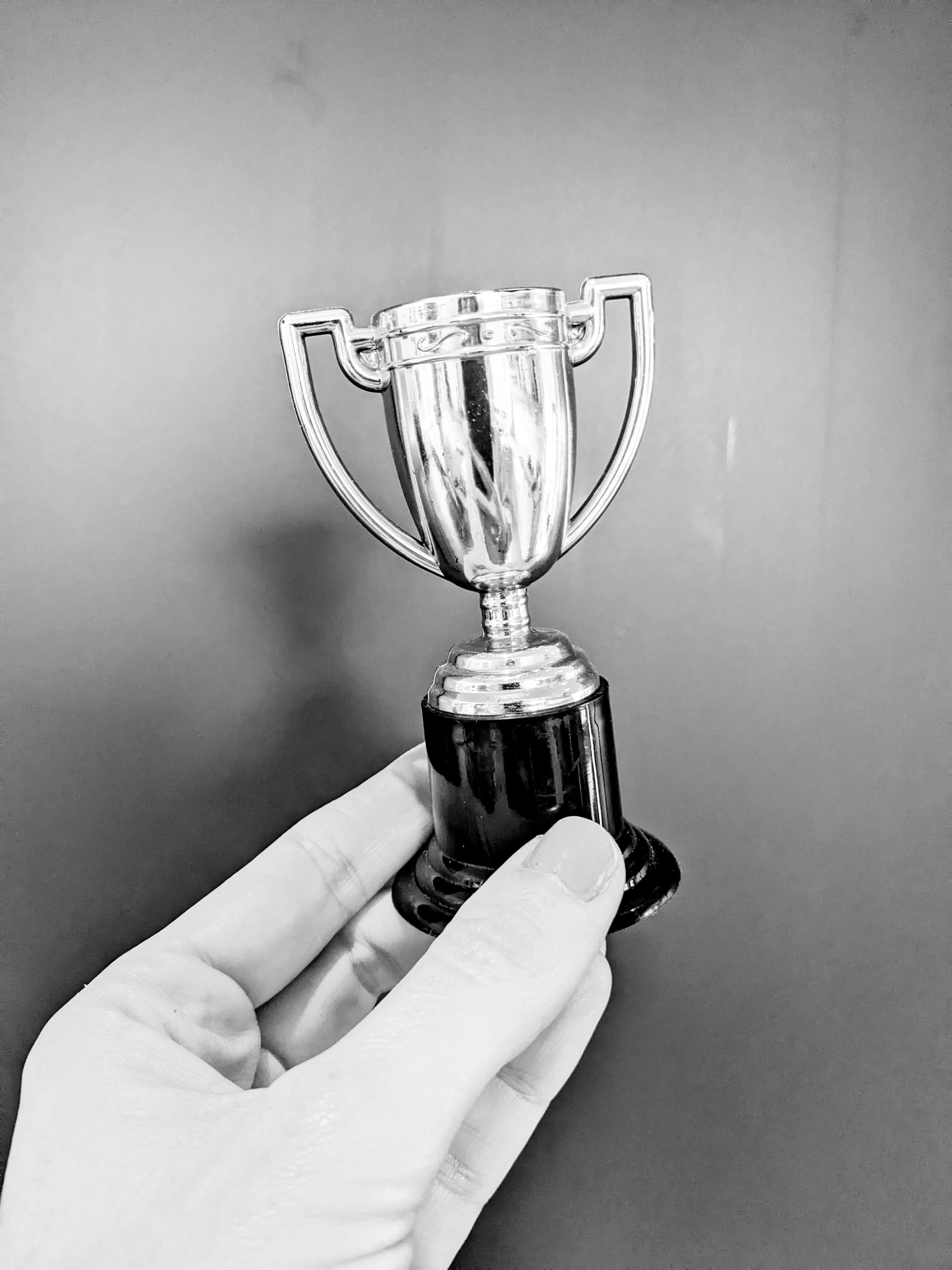 Hand holding trophy in black and white