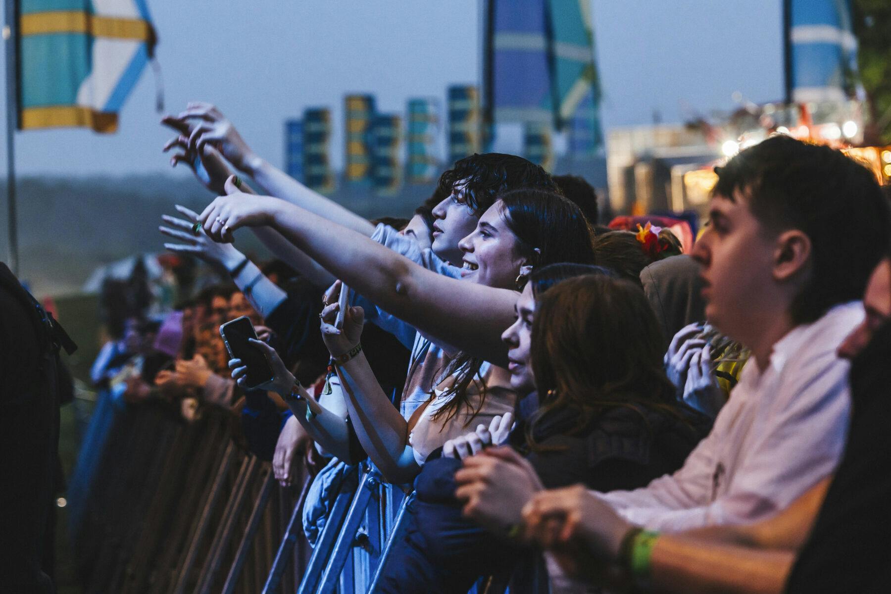 Side view of people in a crowd looking up to a stage.