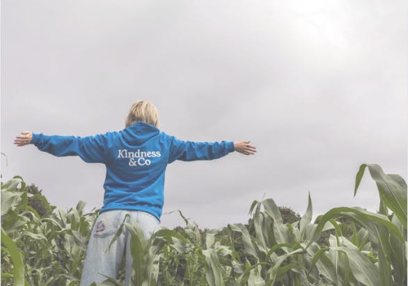 Girl in a cornfield, hands outstretched