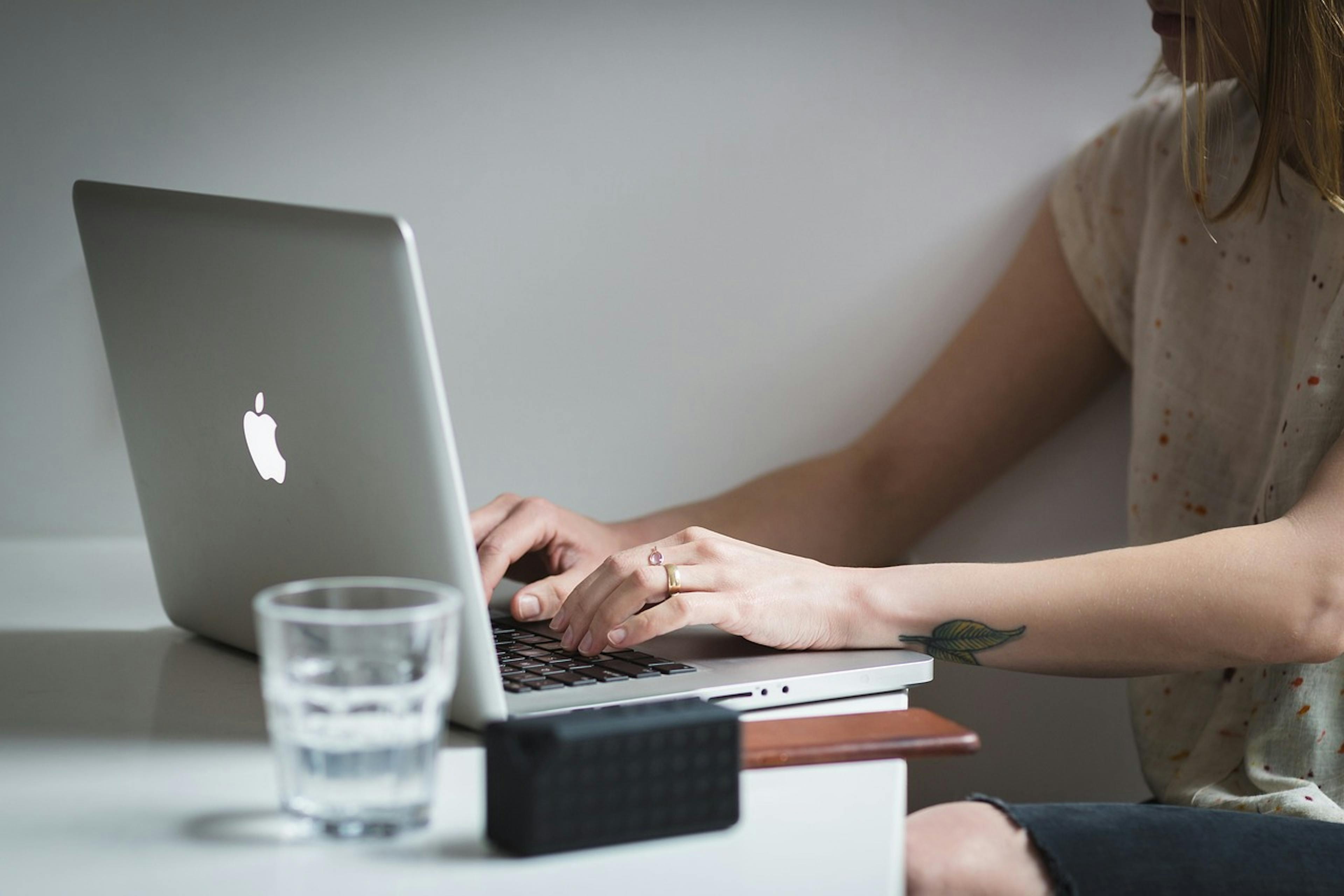 An image of a man making plans on a desk with pens and paper, alongside a phone and a tablet - it is the main image for the article "Best Productivity Apps: The 7 Best Apps of 2025"