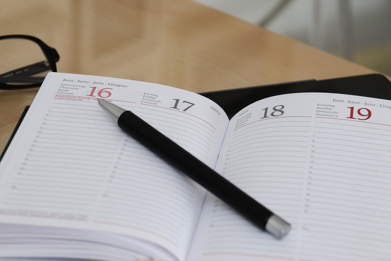 An image of a pen on top of a notebook - it is the main image for the article - "Time Planner: The Top 4 Time Planners That Boost Organization"