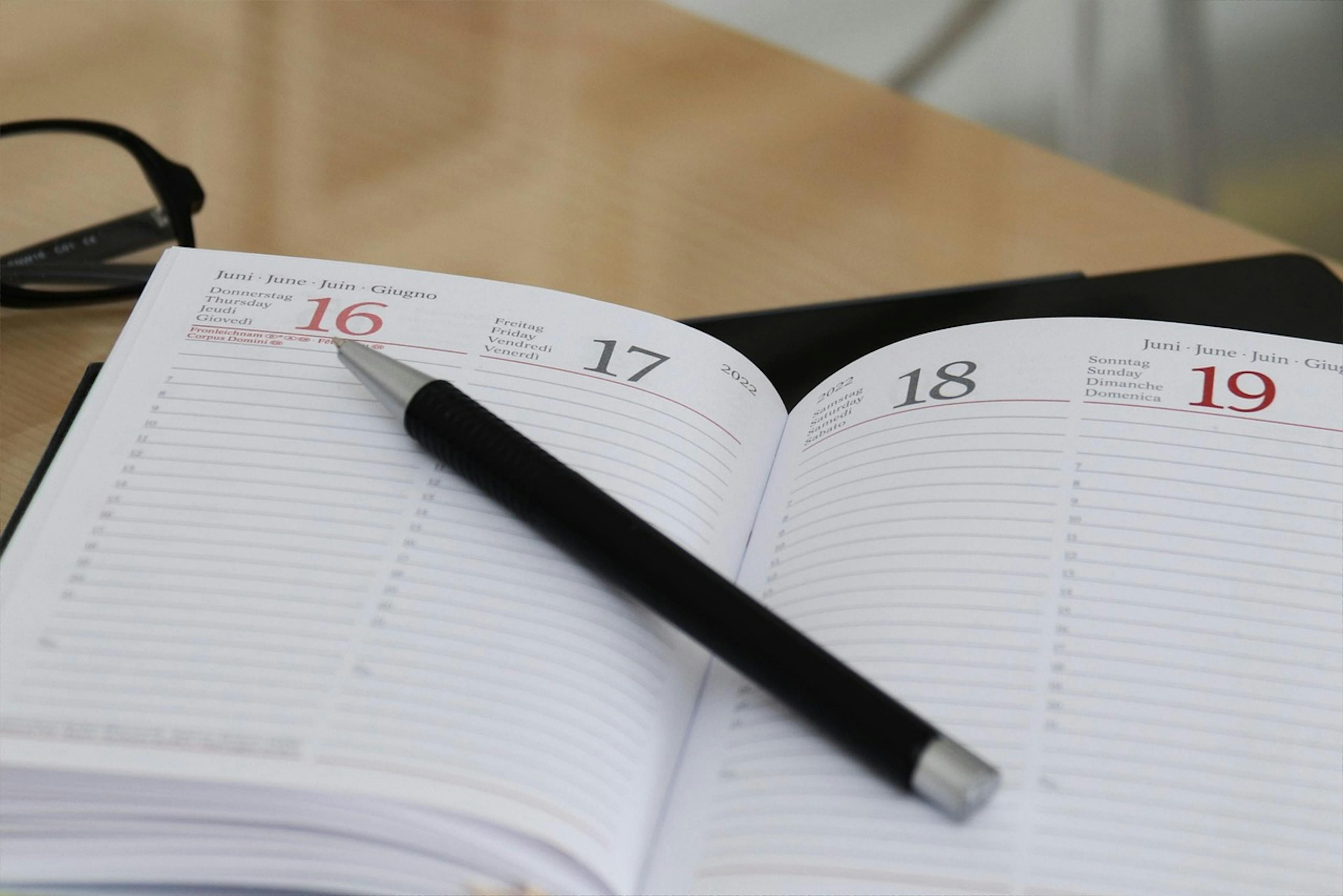 An image of a pen on top of a notebook - it is the main image for the article - "Time Planner: The Top 4 Time Planners That Boost Organization"
