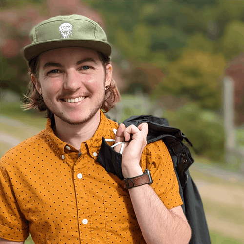 Profile photo of Jackson Bird, wearing an orange button-down shirt and a green hat