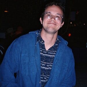 Profile Photo of AJ Jaramaz, wearing glasses and a blue shirt