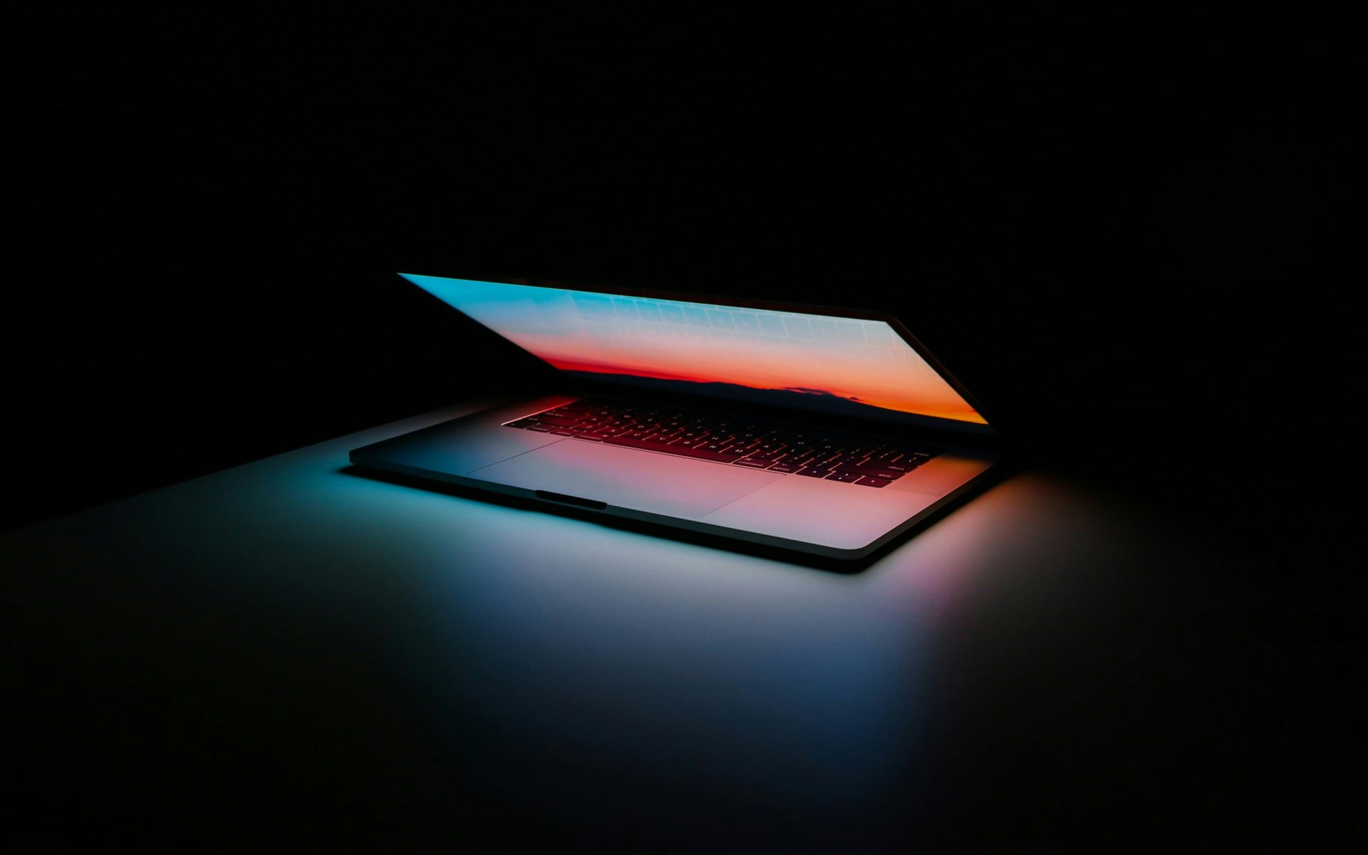 Macbook screen lighting up a dark space