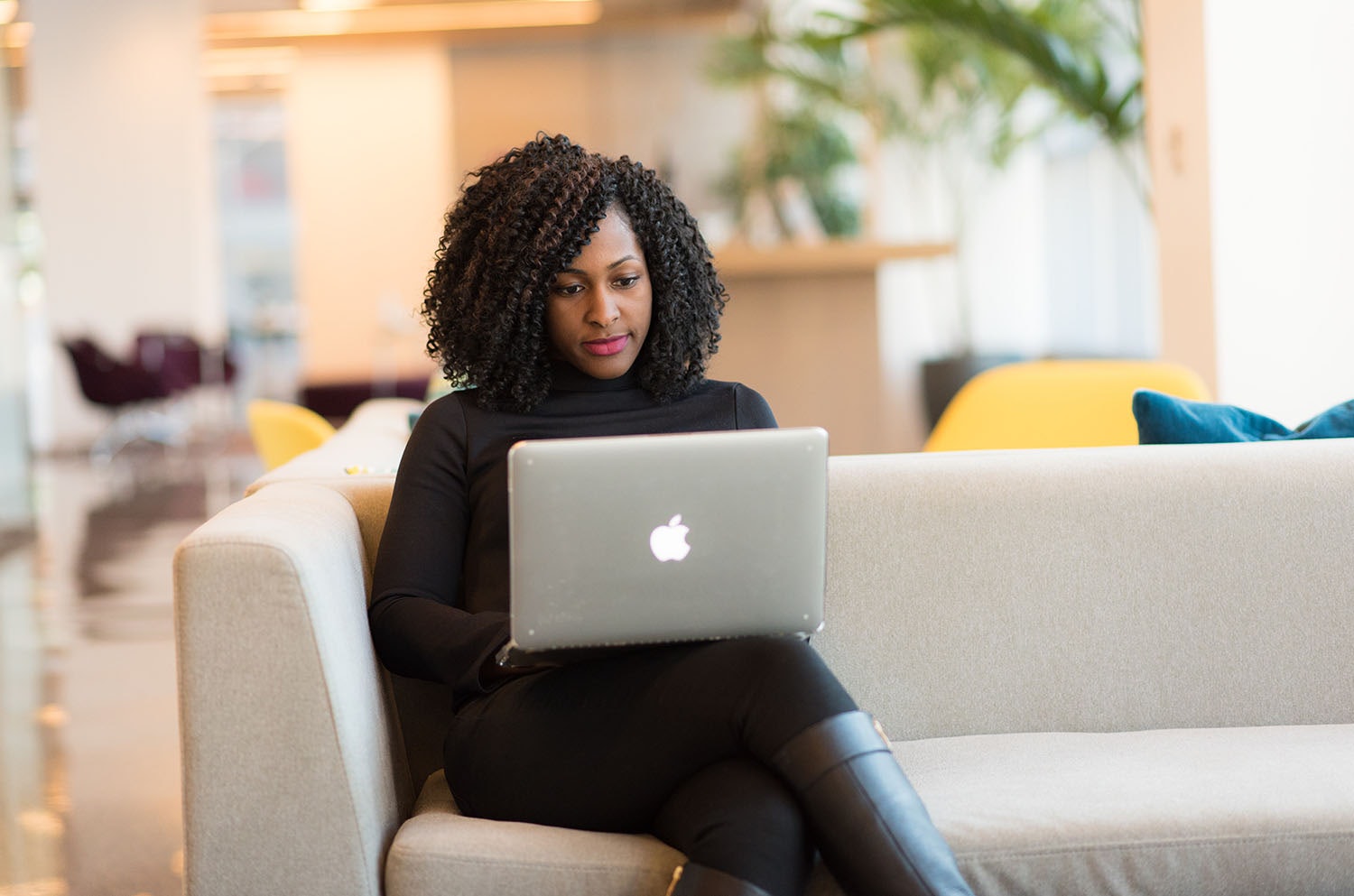 Woman Using Laptop on Sofa
