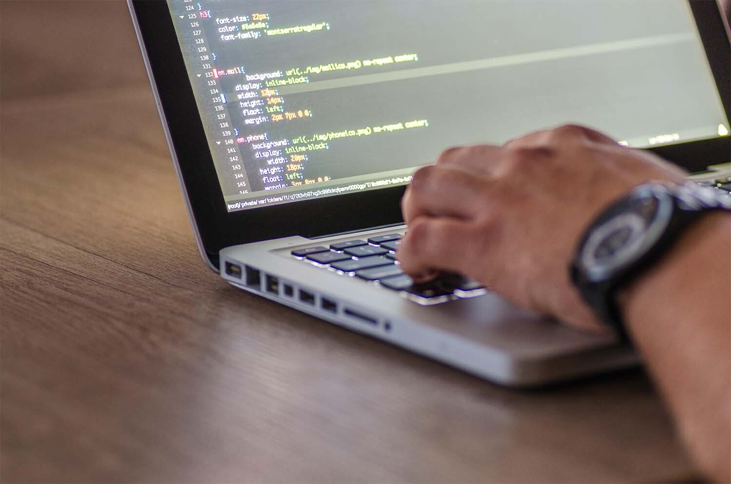 Someone writing code on a laptop