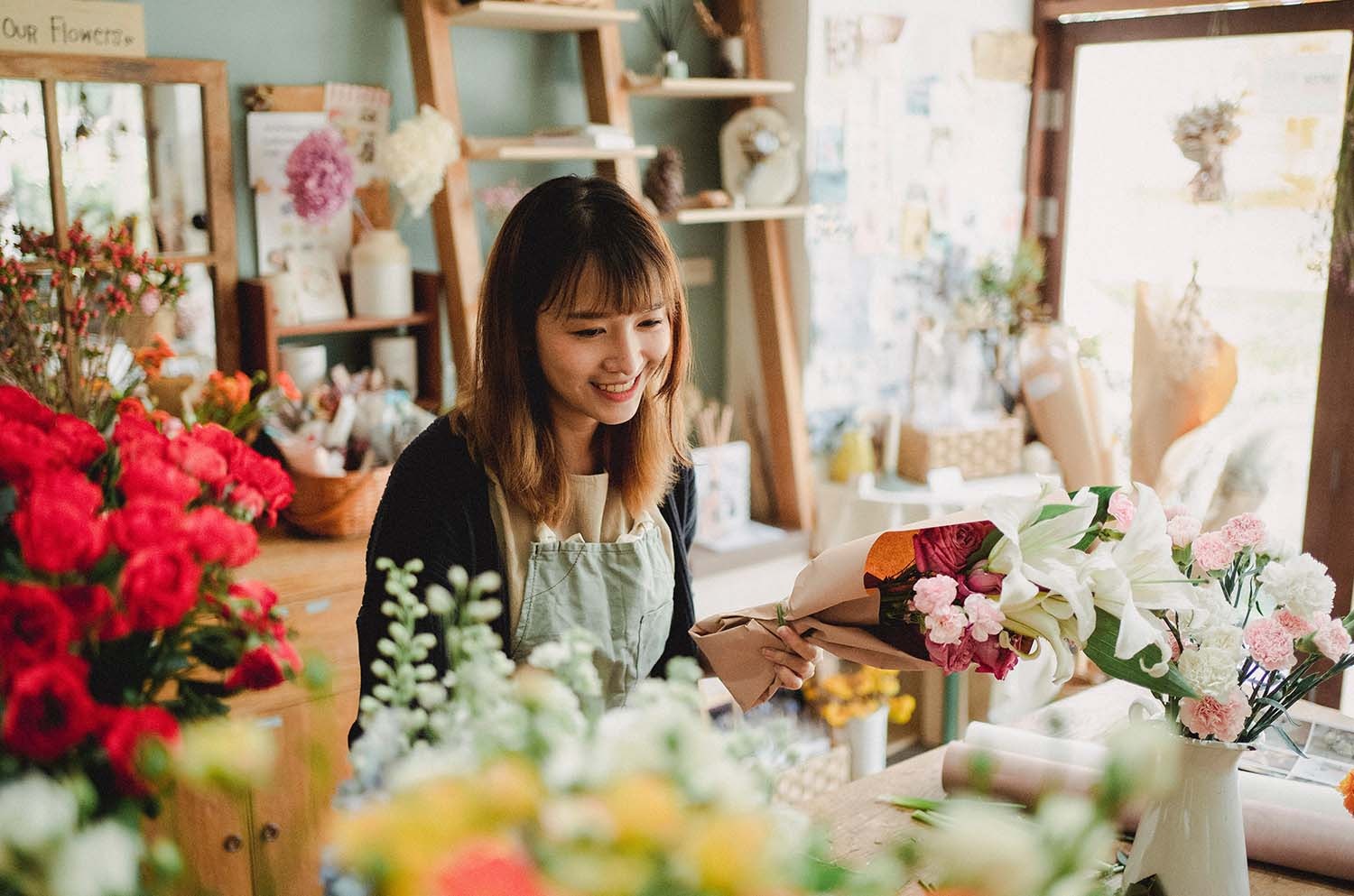 Young Woman Packaging Up Flowers in Her Store