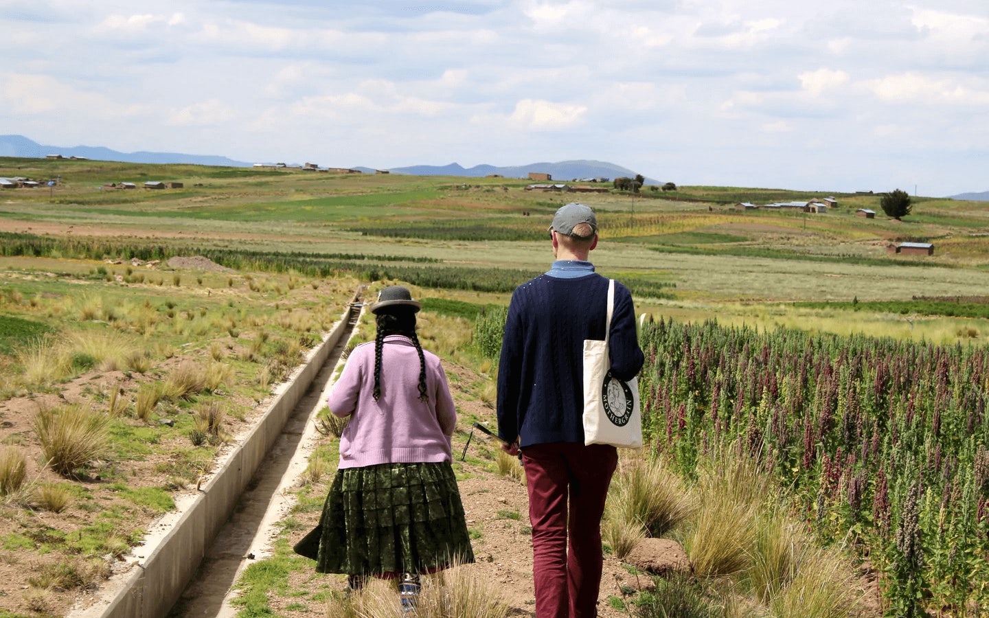 Man and woman walking through a Peruvian field.