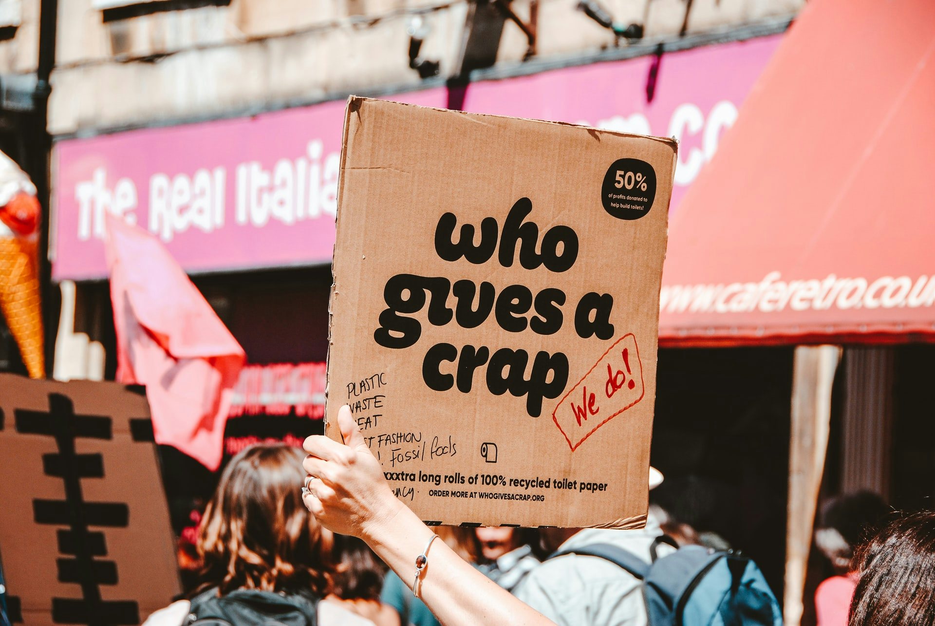 Image of climate protestor holding a cardboard sign.
