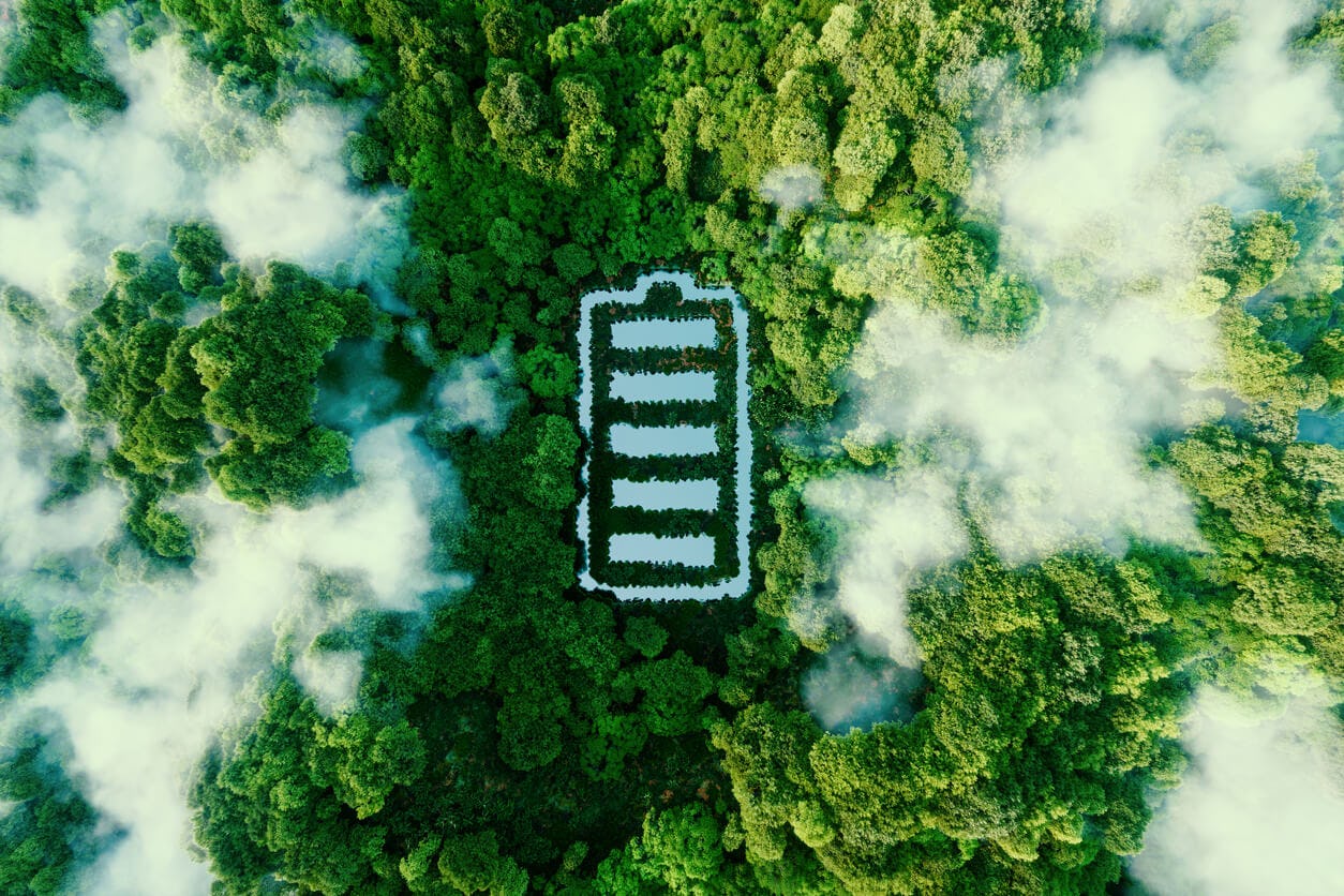 Conceito que retrata armazenamento de energia verde na forma de uma lagoa em forma de bateria localizada em uma floresta exuberante. 