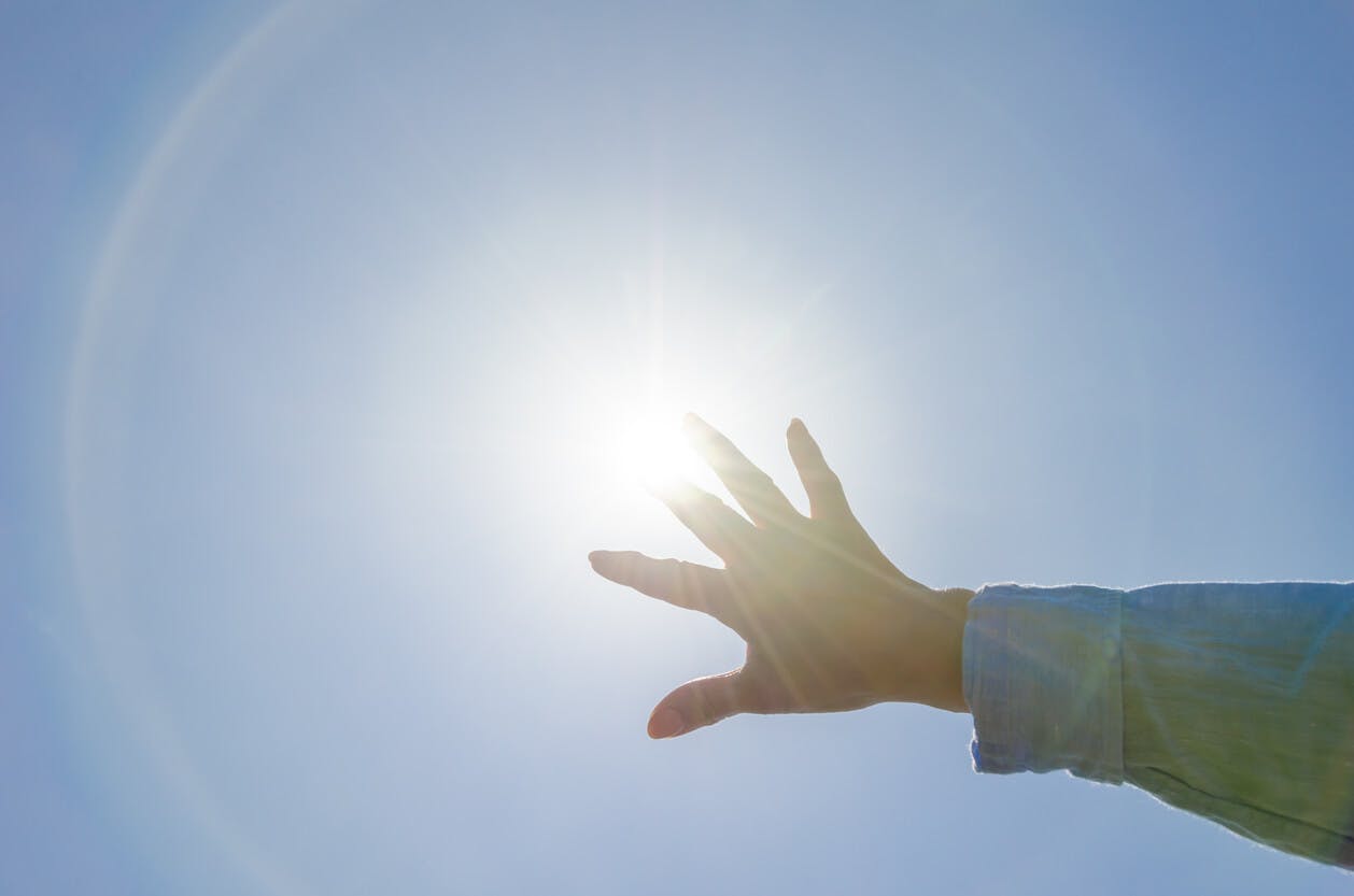 Mão da mulher e o sol