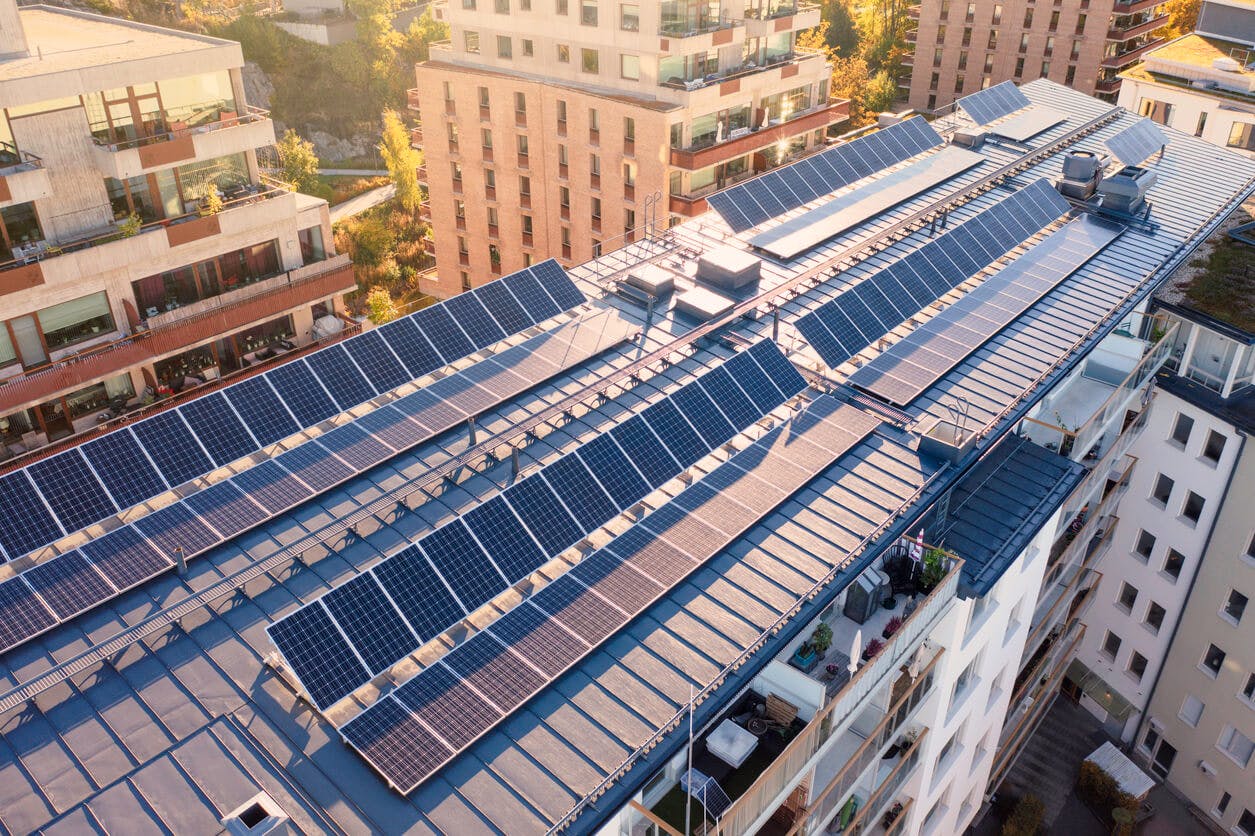 Painéis solares no telhado de um prédio de apartamentos em condomínio. 